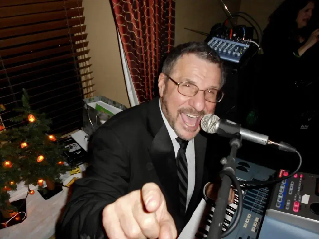 A man in a suit and tie holding a microphone.