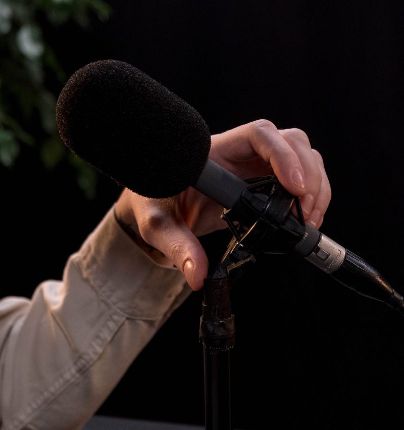 A person holding onto a microphone with one hand